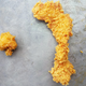Popeyes chicken nugget next to Popeyes chicken strip on sheet tray